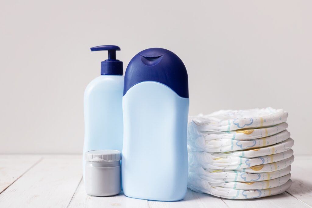 Baby diapers and hygiene products for newborn skin care on a wooden table